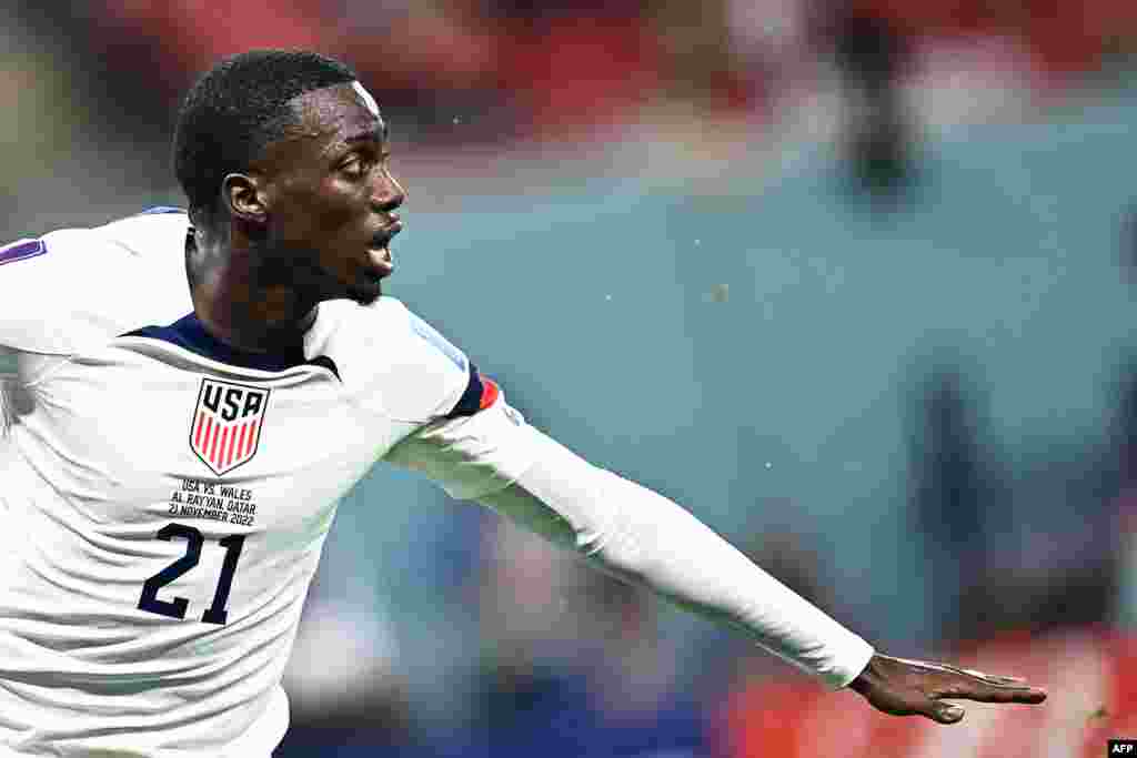 Attaquant ya Etats-Unis #21 Timothy Weah atondi na esengo nsima na kotia mongete na match na Pays de Galles mpo na groupe B ya mondial Qatar 2022, stade Ahmad Bin Ali, Al-Rayyan, west Doha, 21 novembre 2022. (Photo Jewel SAMAD / AFP)