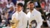 Carlos Alcaraz of Spain holds his trophy as he stands with Novak Djokovic of Serbia after winning the men's singles final at the Wimbledon tennis championships in London, July 14, 2024. 