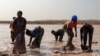 Des femmes lavent le minerai dans une mine artisanale près de la ville de Kolwezi, dans le sud-est de la RDC, le 20 juin 2023.(Photo Emmet LIVINGSTONE / AFP)