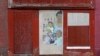 FILE - Artwork covers a boarded-up door outside a blighted building in Baltimore, April 4, 2013. A November 2024 ballot initiative proposes giving new parents in Baltimore a $1,000 “baby bonus” to help reduce childhood poverty.