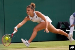 Jasmine Paolini of Italy plays a forehand return to Barbora Krejcikova of the Czech Republic during the women's singles final at the Wimbledon tennis championships in London, July 13, 2024.