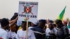 Un manifestatant tient une pancarte sur laquelle on peut lire "à bas la CEDEAO, vive l'ASS" lors d'un rassemblement pour célébrer le départ du Mali, du Burkina Faso et du Niger de la CEDEAO, à Bamako, le 1er février 2024. (Photo OUSMANE MAKAVELI / AFP)