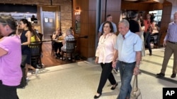 Cousins Ann Meddin Hellman, left, and Shalom Korai walk, talk, and hold hands after meeting in person for the first time in North Charleston, South Carolina, July 10, 2024.