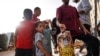 Palestinians collect food from airdropped aid parcels in the Hamad City area in Khan Yunis in the southern Gaza Strip on July 4, 2024.