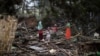 Sejumlah warga duduk dan berdiri di atas rumah mereka yang hancur di kamp pengungsi Basara di Sittwe pada 16 Mei 2023, setelah topan Mocha menghantam wilayah itu, 16 Mei 2023. (Foto: Sai Aung Main/AFP).