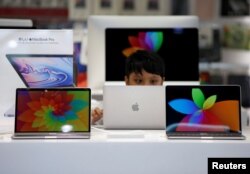 Seorang anak laki-laki menggunakan laptop Apple di sebuah toko komputer di Tokyo, Jepang, 10 Mei 2019. (REUTERS/Issei Kato)