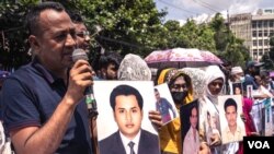 গুমের শিকার হওয়া আত্মীয়দের ছবি নিয়ে মানুষ ২০২২ সালের ৩০ আগস্টে বাংলাদেশের ঢাকায় একটি নীরব সমাবেশে অংশ নেয়। (ভয়েস অফ আমেরিকার জন্য আবদুর রাজ্জাকের ছবি।)