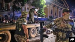 Grup Wagner menjaga area saat yang lain memuat tank mereka ke truk di sebuah jalan di Rostov-on-Don, Rusia, Sabtu, 24 Juni 2023. (Foto: via AP)