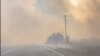 A motorist drives past the Gwen fire on Highway 3 outside of Juliaetta, Idaho on July 25, 2024. Multiple communities in Idaho have been evacuated after lightning strikes sparked fast-moving wildfires. (William Howard via AP)