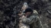 A Ukrainian serviceman stands near a tank, as Russia's attack on Ukraine continues, near the front line city of Bakhmut, Ukraine, April 10, 2023.