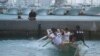 Penduduk setempat berlatih mendayung perahu nelayan tradisional untuk festival mendatang, yang diikat dengan tali di sebuah pelabuhan saat Topan Mawar bergerak menuju pulau Okinawa di Itoman, Jepang selatan, Rabu, Mei 31, 2023. (AP/Hiro Komae)