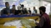 Afghan men wait to receive their passports from the main post office in Kabul, Afghanistan, July 3, 2024. 