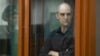 Wall Street Journal reporter Evan Gershkovich stands in a glass cage in a courtroom in Yekaterinburg, Russia, June 26, 2024.