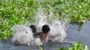 Children bathe in the Buriganga river on a hot summer day in Dhaka, Bangladesh, on April 19, 2023. 