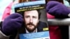 FILE - A demonstrator holds a flier with a photo of detained Belgian aid worker Olivier Vandecasteele, at a rally organized by Amnesty International and a support committee to ask for his liberation, in Brussels, Jan. 22, 2023.