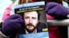 FILE - A demonstrator holds a flier with a photo of detained Belgian aid worker Olivier Vandecasteele, at a rally organized by Amnesty International and a support committee to ask for his liberation, in Brussels, Jan. 22, 2023.