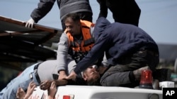 An injured Palestinian is lifted onto an ambulance during clashes with Israeli forces in the West Bank city of Nablus, Feb. 22, 2023. 