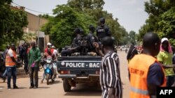 Petugas kepolisian berpatroli di tengah aksi protes yang menuntut pemerintah untuk lebih memberi perhatian pada kondisi kemananan di Burkina Faso. Aksi tersebut berlangsung di Ouagadougou, Burkina Faso, pada 3 Juli 2021. (AFP/Olympia De Maismont) 