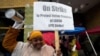 Teacher Sarah Harris joins Los Angeles Unified School District, LAUSD teachers and Service Employees International Union 99 members striking as rain falls outside the Edward R. Roybal Learning Center in Los Angeles, March 21, 2023. 