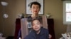 FILE - Sophie Luo Shengchun, the wife of jailed Chinese human rights lawyer, Ding Jiaxi, poses with a photo of him at her home in Alfred, New York, July 28, 2022. 