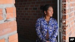 Chhem Hay, 37, stands at a main door of her house under construction at Run Ta Ek village in Siem Reap province, Cambodia, on April 2, 2024.