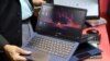 Seorang pria memegang laptop produksi Reliance yang akan segera diluncurkan dengan nama pasar "JioBook", di kios Jio pada acara "India Mobile Congress 2022" di Pragati Maidan, New Delhi, India, 3 Oktober 2022. (REUTERS/Anushree Fadnavis)