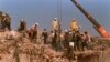 FILE - Rescue workers sift through the rubble of the U.S. Marine base in Beirut in Oct. 23, 1983, following a massive bomb blast that destroyed the base and killed 241 American servicemen.
