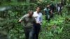 French President Emmanuel Macron walks with Gabon's Minister of Water and Forests Lee White while during his visit to the Mondah classified forest on the sidelines of the One Forest Summit in Libreville, Gabon, March 2, 2023.