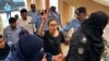 Petugas polisi menghadirkan pengacara dan aktivis hak asasi manusia yang ditangkap, Imaan Mazari-Hazir (tengah) di hadapan pengadilan di Islamabad pada 20 Agustus 2023. (Foto: AFP)