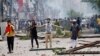 FILE - A demonstrator gestures as protesters clash with Border Guard Bangladesh and the police outside the state-owned Bangladesh Television as violence erupts across the country after anti-quota protests by students, in Dhaka, Bangladesh, July 19, 2024. 