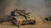 An Israeli soldier moves on the top of a tank near the Israeli-Gaza border, as seen from southern Israel, July 14, 2024. 