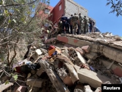Para petugas SAR melakukan operasi pencarian korban di sebuah geedung yang runtuh menyusul gempa hebat di Amizmiz, Maroko, Sabtu, 9 September 2023. (Foto: Abdelhak Balhaki/Reuters)