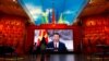 Pengunjung berdiri di depan layar raksasa yang menampilkan Presiden China Xi Jinping di samping bendera Partai Komunis China, di Museum Militer Revolusi Rakyat China di Beijing, China 8 Oktober 2022. (Foto: REUTERS/Florence Lo)