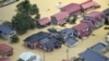 An aerial view shows a Japan Self-Defense Forces helicopter conducting a search and rescue operation over a flooded residential area in Tozawa Town, Yamagata Prefecture, Japan, July 26, 2024, in this photo taken by Kyodo.