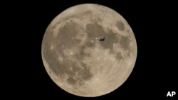 FILE - A plane passes in front of the moon, Aug. 30, 2023, in Chicago, Illinois.
