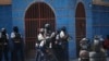 FILE - Police officers take cover during an anti-gang operation in the Lalue neighborhood of Port-au-Prince, Haiti, March 3, 2023. 