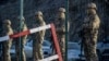 FILE - Azerbaijani servicemen stand guard at a checkpoint at the Lachin corridor, the Armenian-populated breakaway Nagorno-Karabakh region's only land link with Armenia, Dec. 27, 2022.