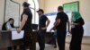 Voters line up to get their ballots at a polling station during a referendum in Tashkent, Uzbekistan, April 30, 2023.
