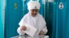 A woman wearing Kazakh National Costume casts her ballot at a polling station in Astana, Kazakhstan, March 19, 2023.