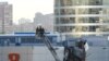 Para penyelidik sedang memeriksa atap yang rusak menyusul laporan tentang drone Ukraina yang ditembak jatuh di Moskow, Rusia, 18 Agustus 2023. (Foto: Shamil Zhumatov/Reuters)
