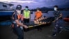 Anggota BASARNAS membawa kantong mayat saat melakukan operasi pencarian pengungsi Rohingya yang hilang di dekat Calang, Aceh Barat, pada 23 Maret 2024. (Foto: AFP/Zahlul AKBAR)