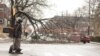A man walks near fallen branches a day after freezing rain and strong winds cut power to more than a million people in Canada's two most populated provinces, in Montreal, Quebec, April 6, 2023. 