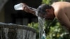 Seorang pria menyiramkan air untuk mengatasi suhu ekstrem gelombang panas di Guadalajara, negara bagian Jalisco, Meksiko, 12 Juni 2023. (Foto: Ulises Ruiz/AFP)