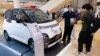Seorang salesman menjelaskan spesifikasi mobil listrik Wuling Air EV buatan China kepada pengunjung di pusat perbelanjaan di Jakarta, 5 Februari 2023. (Foto: Reuters)