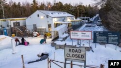 FILE - Aerial view shows migrants from Venezuela, Nigeria, Haiti and other countries at the Roxham Road border crossing in Roxham, Quebec, March 3, 2023.