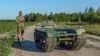 Andrii Denysenko, CEO of design and production bureau "UkrPrototyp," stands by Odyssey, an 800-kilogram ground drone prototype, at a corn field in northern Ukraine, June 28, 2024.