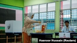 Seorang pemilih sedang memasukkan surat suara dalam pemilu negara bagian di Selayang, Malaysia, Sabtu, 12 Agustus 2023 (Foto: Hasnoor Hussain/Reuters)