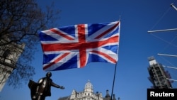 Bendera Inggris berkibar saat demonstrasi March to Leave di alun-alun Parlemen di London, Inggris, 29 Maret 2019. (Foto: REUTERS/Toby Melville)