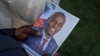 ARCHIVO - Una persona sostiene una fotografía del fallecido presidente haitiano Jovenel Moïse en la casa de su familia en Cabo Haitiano, Haití, el 23 de julio de 2021. Moïse fue asesinado ese mes en su residencia de Puerto Príncipe.