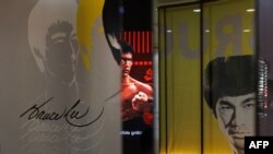 Pengunjung menonton film dokumenter di pameran Bruce Lee di Hong Kong Heritage Museum di Hong Kong, 15 Juli 2023, menjelang peringatan 50 tahun kematian bintang seni bela diri tersebut 20 Juli 2023. (May JAMES / AFP)